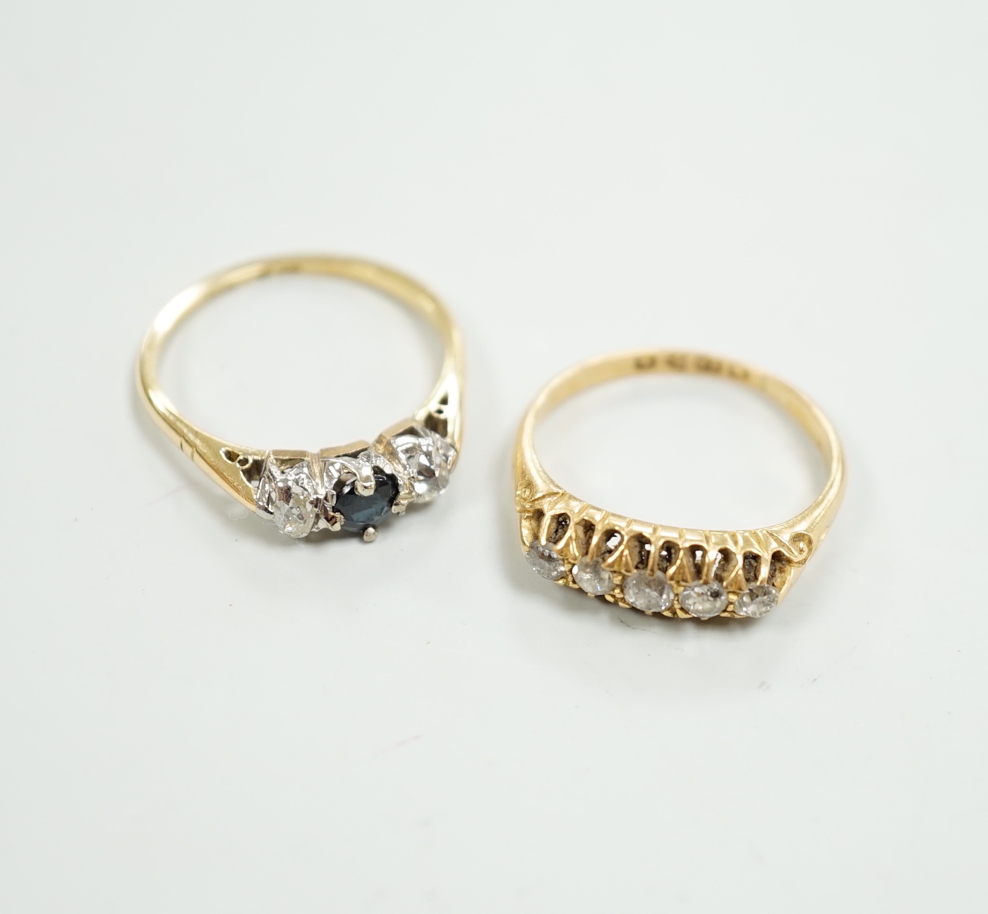 A George V 18ct gold and graduated five stone diamond chip set half hoop ring, size O and a similar 18ct, sapphire and diamond set three stone ring, gross weight 6 grams.